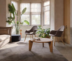 Stylish round coffee table with books and decorative flowers in a modern living room